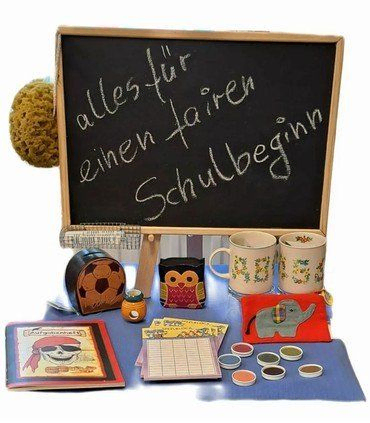 Tafel mit "fairer Schulbeginn" Botschaft, umgeben von Schulmaterialien.